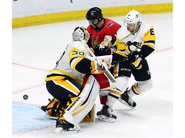 Pittsburgh Penguins goalie Matt Murray (30) makes a save as teammate Chad Ruhwedel (2) and the Ottawa Senators' Alexandre Burrows look for the puck.