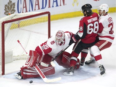 Detroit Red Wings defenceman Mike Green sends Ottawa Senators left wing Mike Hoffman into goalie Jimmy Howard as he keeps his eye on the puck during first-period NHL action on Thursday, Nov. 2, 2017 in Ottawa.