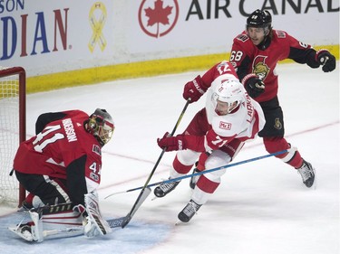Ottawa Senators left wing Mike Hoffman, right, loses his stick as Detroit Red Wings centre Dylan Larkin fires the puck wide of the net and Senators goalie Craig Anderson.