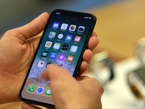 Customers setup an iPhone X at an Apple showroom in Sydney on November 3, 2017. Apple iPhone X went for sale in Australia with long queues outside the Apple stores. (SAEED KHAN/AFP/Getty Images)