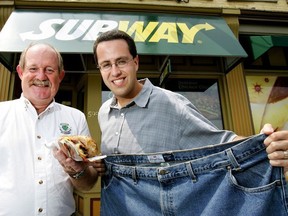 Ex-Subway spokesman Jared Fogle holds up a pair of his old 60 inch waist jeans from his 425lb days with Dr. Larry Patrick, the medical director of the Cardiac Fitness Institute (CFI) in London, Ontario on August 9, 2005.