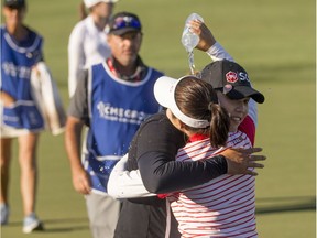 Ariya Jutanugarn is embraced by her sister Moriya Jutanugarn after sinking a birdie putt on No.18 to claim outright victory in the CME Group Tour Championship at Naples, Fla. Luke Franke/Naples Daily News via AP