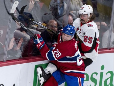 The Ottawa Senators' Erik Karlsson is checked into the boards by the Montreal Canadiens' Jakub Jerabek.