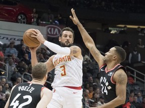 Atlanta Hawks guard Marco Belinelli (3) goes high to pass while Toronto Raptors center Jakob Poeltl (42), of Austria, and forward Norman Powell (24) defend during the first half of a NBA basketball game, Saturday, Nov. 25, 2017, in Atlanta. THE ASSOCIATED PRESS