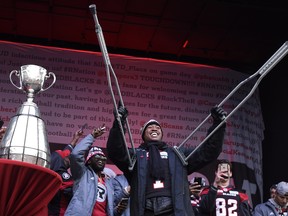 Ottawa Redblacks Henry Burris raises his crutches as he reacts to the crowd during a rally at Aberdeen Square celebrating the team's victory over the Calgary Stampeders, in the  2016 Grey Cup.