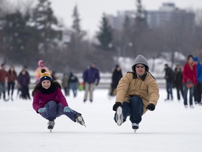 Bruce Driver (right), former NHL player for the New Jersey Devils, and his niece Hannah Driver, "shoot the duck" to entertain their friends as they skate along the Rideau Canal Skateway