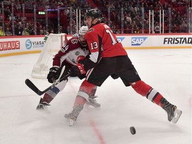 The Colorado Avalanche's Mark Barberio and the Ottawa Senators' Nick Paul battle for the puck.