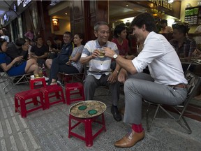 Canadian Prime Minister Justin Trudeau speaks with Nguyen Cong Hiep as the two stop for a drink at local cafe in Ho Chi Minh, Vietnam Thursday November 9, 2017. The PM, since he's abroad, won't be at Saturday's Remembrance Day ceremony. THE CANADIAN PRESS/Adrian Wyld