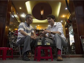 Canadian Prime Minister Justin Trudeau speaks with Nguyen Cong Hiep as the two stop for a drink at local cafe in Ho Chi Minh, Vietnam Thursday November 9, 2017. Trudeau was travelling for the APEC conference, missing Remembrance Day. THE CANADIAN PRESS/Adrian Wyld