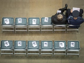 A police officer and a woman wait for a memorial to begin for Abbotsford Police Const. John Davidson, who was killed in the line of duty on Nov. 6, in Abbotsford, B.C., on Sunday November 19, 2017. THE CANADIAN PRESS/Darryl Dyck