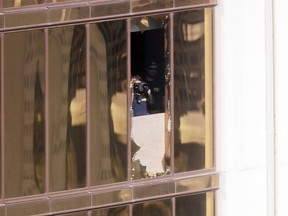 In this Oct. 4, 2017 file photo, investigators work in the room at the Mandalay Bay Resort and Casino in Las Vegas, from which shooter Stephen Paddock carried out his murderous rampage on Oct. 1.