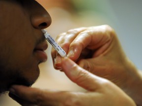 A patient receives a nasal spray vaccine