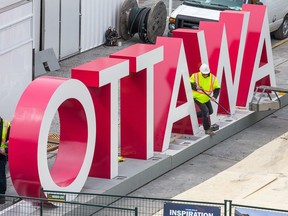 Workers install the OTTAWA sign at Inspiration Village in May 2017.