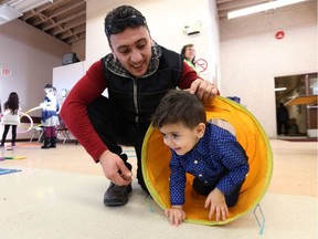 Yasser Jakl plays with son Ali, 2, during a celebration marking the first anniversary of the arrival of Syrian refugees.