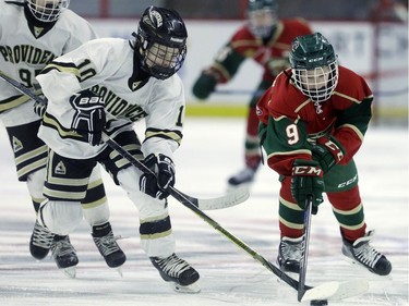 Providence's Owen Leahy, left, challenges Eastern Ontario's Ty Therien, right, for the puck.
