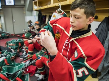 The Wild's Carey Terrance pampers his stick before stepping on the ice Sunday at Canadian Tire Centre.