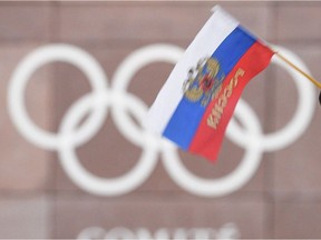 A supporter waves a Russian flag in front of the logo of the International Olympic Committee at their headquarters in Switzerland on Tuesday.