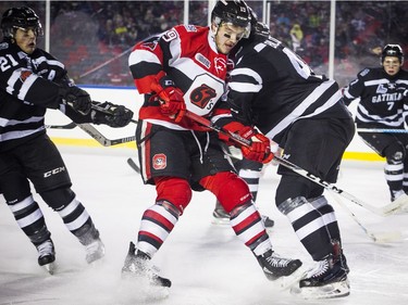 Ottawa 67's #19 Travis Barron battles for the puck against the Gatineau Olympiques during the outdoor game at TD Place for an outdoor game Sunday December 17, 2017.   Ashley Fraser/Postmedia