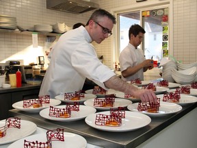 Marc Lepine, award-winning chef and owner of Atelier, seen plating one of the 13 courses served to dinner guests of the Black and White Soiree held at his restaurant, in April, 2016..