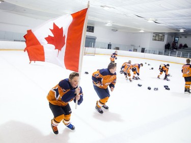 Kanata's Carter Wood does laps of the ice with a maple leaf flag after his team's shootout win over St. Clair Shores.   Ashley Fraser/Postmedia