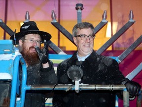 With the help of Rabbi Chaim Boyarsky, and after being given a failed lighter and an iffy blow torch, Ottawa Mayor Jim Watson finally got the centre light lit on the giant menorah outside city hall Tuesday (Dec. 12, 2017) evening to mark the beginning of Hanukkah. Julie Oliver/Postmedia
