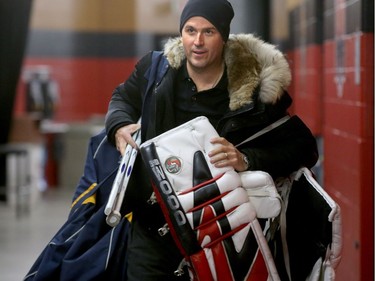 Former goalie Patrick Lalime seems weighed down with all his gear as he arrives at the rink for a warmup practice.