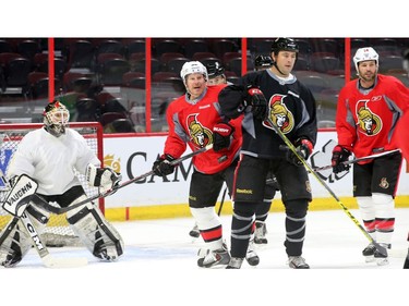 The two captains of the upcoming game, Chris Phillips and Daniel Alfredsson, watch for the puck.
