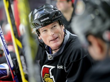 Jim Kyte and other players chat on the bench.