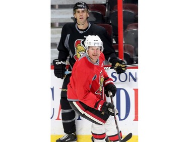 Daniel Alfredsson skates away from Wade Redden.