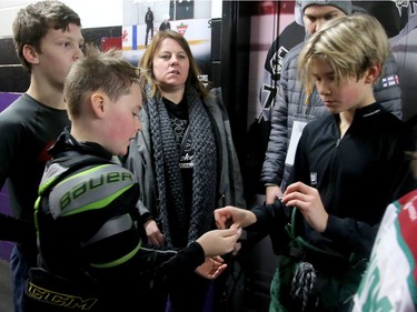 A time-honoured tradition at the worldwide tourney is the swapping of team pins, which a couple of players here do quickly before their game at the Minto Arena.