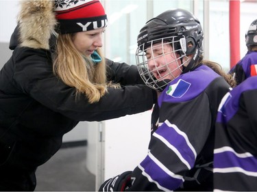 Yukon assistant coach Candice MacEachen assesses one of her players following a shoulder hit in Friday's game.  Julie Oliver/Postmedia