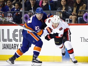 Anders Lee #27 of the New York Islanders and Cody Ceci #5 of the Ottawa Senators battle for the puck during the second period at the Barclays Center  in Brooklyn on Friday. City.  (Photo by Bruce Bennett/Getty Images)