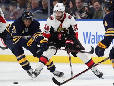 Evander Kane #9 of the Buffalo Sabres and Tom Pyatt #10 of the Ottawa Senators go after a loose puck during the first period at the KeyBank Center on December 12, 2017 in Buffalo, New York.