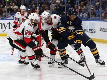 Evander Kane #9 of the Buffalo Sabres tries to take the puck around Matt Duchene #95 and Johnny Oduya #29 of the Ottawa Senators during the second period at the KeyBank Center on December 12, 2017 in Buffalo, New York.