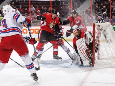 Goalie Craig Anderson, Dion Phaneuf and Erik Karlsson (65) of the Ottawa Senators defend against a shot by Kevin Hayes.