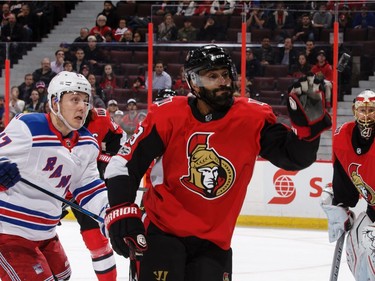 Johnny Oduya of the Ottawa Senators gloves the puck as Jesper Fast of the New York Rangers looks on.