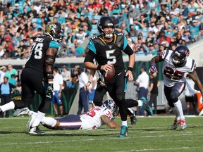 Blake Bortles #5 of the Jacksonville Jaguars looks to pass the football in front of Kareem Jackson #25 of the Houston Texans during the first half of their game at EverBank Field on December 17, 2017 in Jacksonville, Florida.