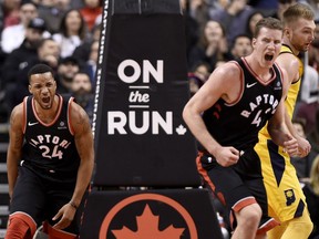 Toronto's Norman Powell, left, reacts after a slam dunk with teammate Jakob Poeltl during second-half play against the Pacers on Friday night.