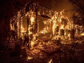 Flames consume a home as a wildfire burns in Ojai, Calif., on Thursday, Dec. 7, 2017.