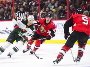 Minnesota’s Nino Niederreiter moves the puck between Ottawa Senators’ Jean-Gabriel Pageau and Cody Ceci late in their game last night. The Sens lost 6-4.  (THE CANADIAN PRESS)