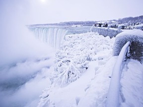 Visitors take photographs at the brink of the Horseshoe Falls in Niagara Falls, Ont., on Friday, Dec. 29, 2017.