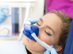 In this stock photo, a woman is sedated with gas in a medical office.