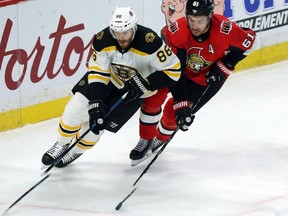 Ottawa's Mark Stone (61) chases down Boston's Kevan Miller (86) as he skates with the puck in the first period.