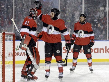 Ottawa Senators defenceman Cody Ceci (5) congratulates goalie Craig Anderson (41) after the final buzzer as Ottawa Senators left wing Zack Smith (15) looks on following third period hockey action against the Montreal Canadiens at the NHL 100 Classic, in Ottawa on Saturday, December 16, 2017.