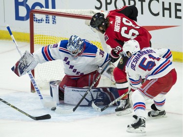 The Senators' Mike Hoffman goes to the net against New York Rangers goalie Henrik Lundqvist  while under pressure from David Desharnais.