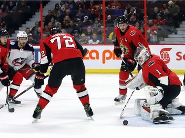 Senators goalie Mike Condon keeps his eye on a loose puck as teammates Dion Phaneuf (2), Thomas Chabot (72) and Jean-Gabriel Pageau (44) and the Blue Jackets' Tyler Motte (64) look on during the first period.