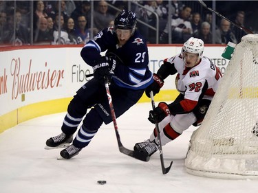 Winnipeg Jets' Patrik Laine (29) battles with Ottawa Senators' Thomas Chabot (72) behind the Senators net during first period NHL hockey action in Winnipeg, Sunday, December 3, 2017.