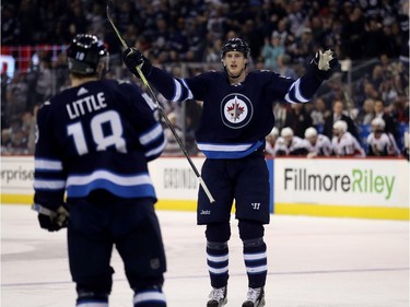 Winnipeg Jets' Tyler Myers (57) celebrates with Bryan Little (18) after scoring against the Ottawa Senators during second period NHL hockey action in Winnipeg, Sunday, December 3, 2017.