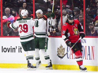 Minnesota Wild's Chris Stewart, centre, and Nate Prosser celebrate a goal as Ottawa Senators' Erik Karlsson skates past during second period NHL hockey action in Ottawa on Tuesday, Dec. 19, 2017.