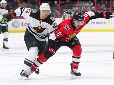 Minnesota Wild's Nino Niederreiter, left, fights to get ahead of Ottawa Senators' Cody Ceci during first period NHL hockey action in Ottawa on Tuesday, Dec. 19, 2017.